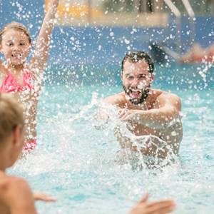 Familie tobt im Wasser herum und haben viel Spaß