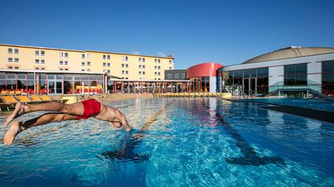 Mann springt in das H2O Sportbecken rein